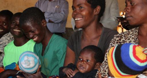 Mothers wait for their five-month old children to receive the first dose of the malaria vaccine