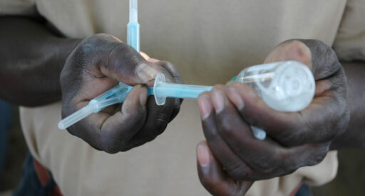 A man loads a needle with a vaccine