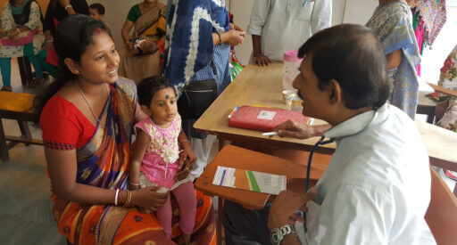 A doctor talking with a female patient and her child in Kolkata, India