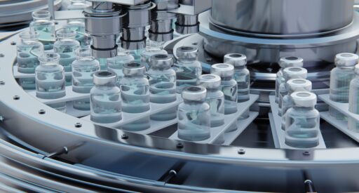 Vaccine manufacturing, machine puts caps on bottles vials passing on conveyor belt. Credit: iStock/volodyar
